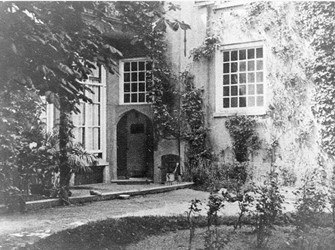 <p>Tuin van de familie Nagell gefotografeerd omstreeks 1935-1940. Op de foto is rechts de zijgevel van het achterhuis en links de achtergevel van het hoofdhuis te zien. De met een spitsboog afgesloten toegang en de vensters daar boven en naast zouden enkele jaren later bij de verbouwing tot arbeidsbureau veranderd worden. </p>
